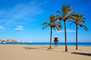 Ein Strand mit Palmen und einem Rettungsturm.