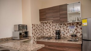 A kitchen with granite countertops, a coffee maker, a toaster, and a refrigerator. - Hot tub studio Ground floor AC (Medellin)