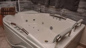 A large, rectangular hot tub with multiple jets, a built-in seat, and a control panel. - Hot tub studio Ground floor AC (Medellin)