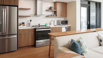 Eine moderne Küche mit Edelstahlgeräten, Holzschränken und einem Holztisch.