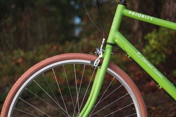 Primer plano de una bicicleta verde con la palabra 'PRIORITY' en el cuadro.