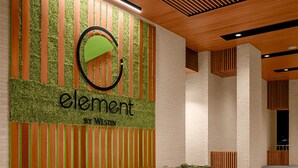 A modern interior with a green and orange wall design, a bench, and a wooden ceiling. - Element by Marriott Nashville Vanderbilt West End (Nashville)