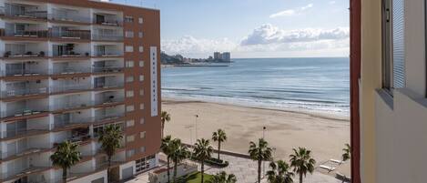 Ein Mehrstöckiges Hotel mit Balkonen mit Blick auf einen Strand.