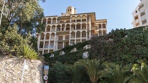Un edificio de varios pisos con arquitectura mediterránea, con balcones y una cúpula central.