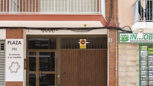 Ein Laden mit einem Schild für 'Plaza' und einer Holztür.