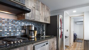 Una cocina moderna con estufa a gas, electrodomésticos de acero inoxidable y lavavajillas.