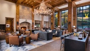 A spacious lobby with a fireplace, comfortable seating, and large windows offering a view of the outdoors. - Beaver Creek Park Hyatt 2 Bedroom Residence (Avon)