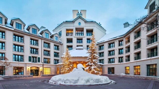 A multi-story hotel with a symmetrical facade, large windows, and a central entrance with a snow-covered decorative feature. - Beaver Creek Park Hyatt 2 Bedroom Residence (Avon)