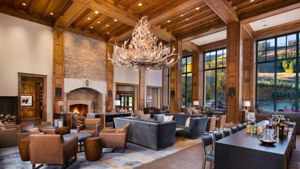 A spacious lobby with a fireplace, comfortable seating, and large windows offering a view of the outdoors. - Beaver Creek Park Hyatt 3 Bedroom Residence (Avon)