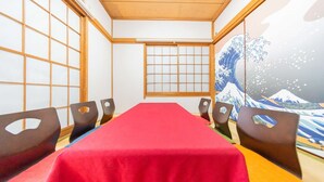 Une pièce de style japonais traditionnel, avec un sol recouvert de tatamis, une table rouge et des paravents en papier de riz (shoji).