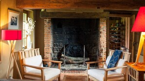 Una habitación acogedora con chimenea de ladrillo, muebles de madera y una lámpara roja.