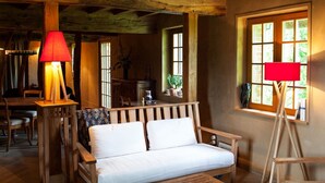 Un interior rústico con un banco de madera, una mesa y una lámpara.