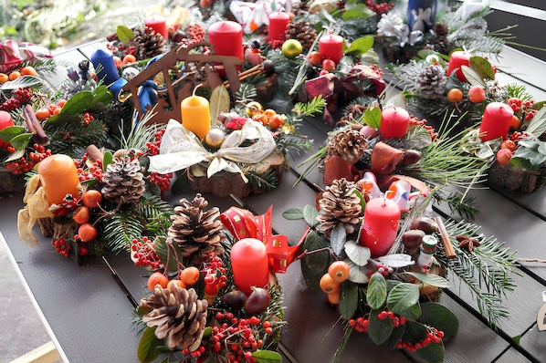 Una mesa decorada con elementos variados como velas, piñas y follaje.