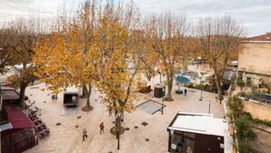 An outdoor plaza with trees, seating areas, and a building with a flat roof. - 1 Bedroom Flat Quartier Rotonde - Lift, Wifi, Air Conditionning / 1 to 6 People (Aix-en-Provence)