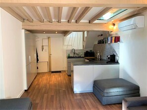 Cuina compacta amb una illa central, forn de sobre i una petita zona de seients.