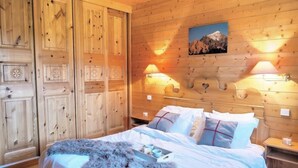 Ein Schlafzimmer aus Holz mit einem Bett, Kissen und einem Nachttisch.