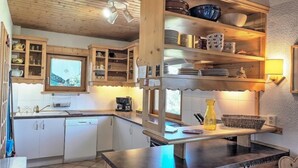 Eine Küche mit Holzausstattung, einer Kaffeemaschine und einem Spülbecken.