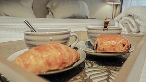 A breakfast tray with croissants and a cup of coffee on a hotel bed. - Le Cairn, stunning 14 person, 7 bedroom chalet with sauna & games room (Peisey Nancroix)