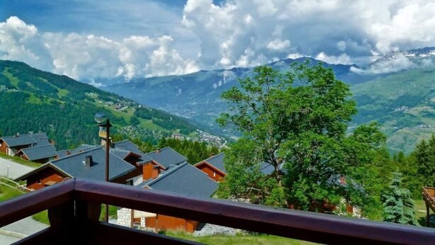 A mountain village with traditional wooden houses, a clear sky, and a view of distant mountains. - Light, bright 2 bed apartment for 6 people with lovely views and close to lifts (Landry)