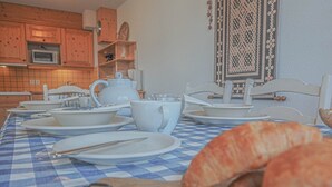A dining table with white plates, cups, and a teapot, set for breakfast. - Light, bright 2 bed apartment for 6 people with lovely views and close to lifts (Landry)