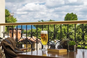 A table with a glass of beer, a book, a helmet, and a plant.