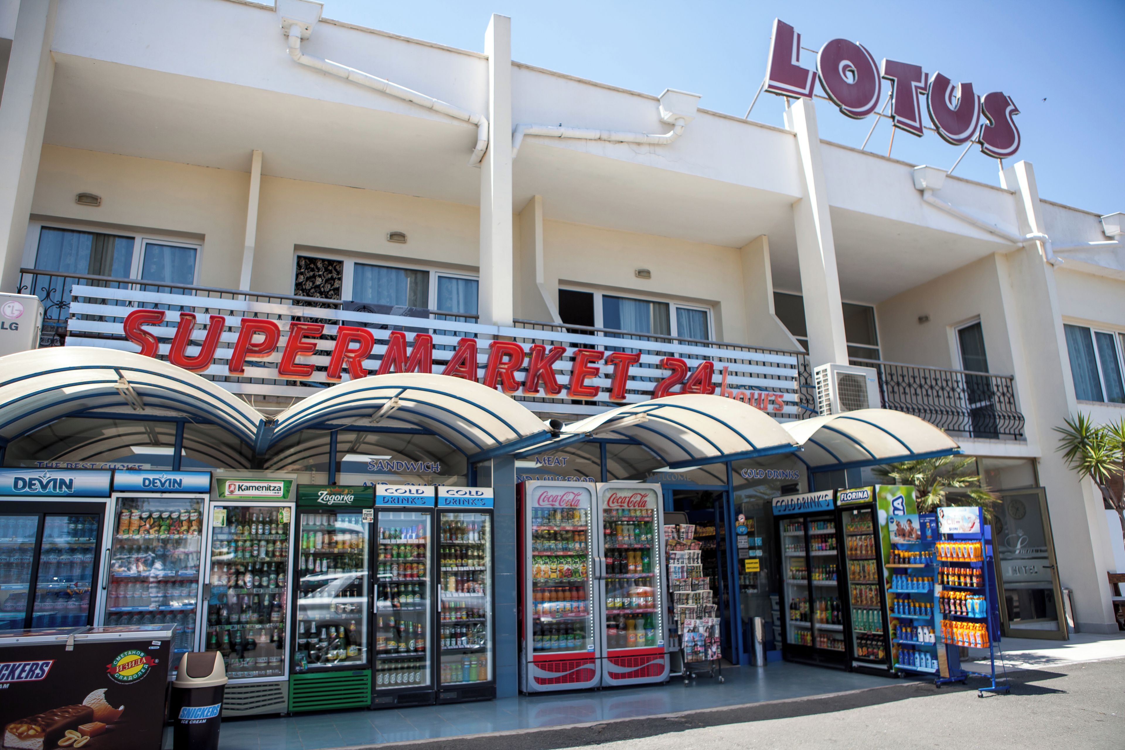 Un supermarché avec une enseigne indiquant « LOTUS SUPERMARKET 24 ».
