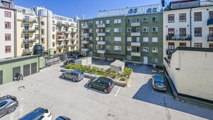 A multi-story residential building with balconies, a parking area, and a small garden. - Hotel Fridhem (Stockholm)