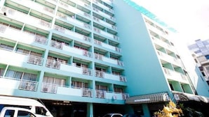 A multi-story hotel with balconies, a flat facade, and a sign indicating it is a hotel.