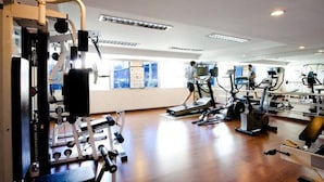 A gym with cardio machines, weight equipment, and a walking path.