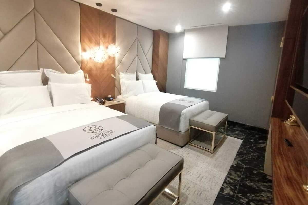 Una habitación de hotel moderna con dos camas, una pared de acento de madera, un ventanal grande y piso de mármol.