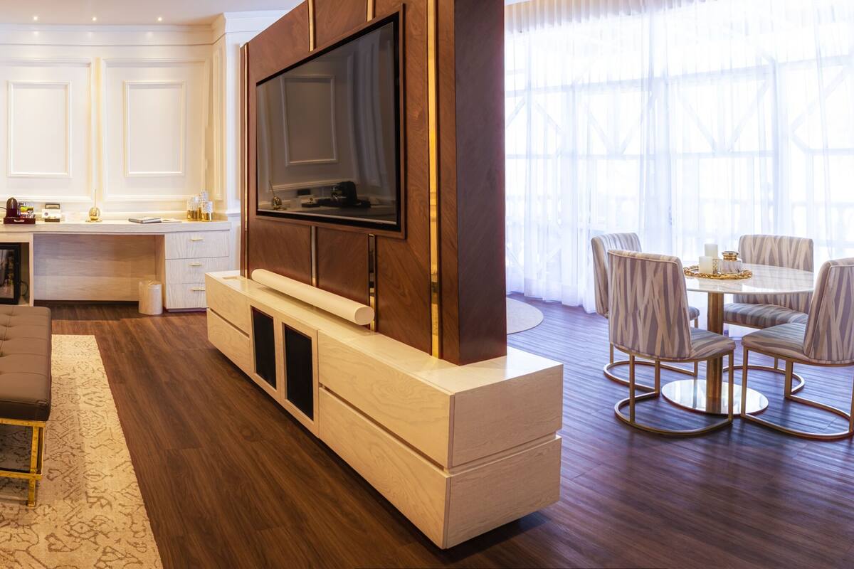 Una habitación de hotel moderna con una cama grande, un escritorio, un televisor y una zona de estar.