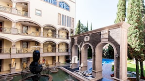Un patio con una fuente, una piscina y un edificio con varios balcones.