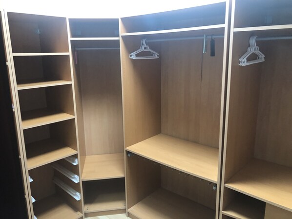 A walk-in closet with multiple shelves and hanging space.