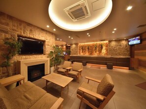 A lobby with a fireplace, seating area, and a reception desk.