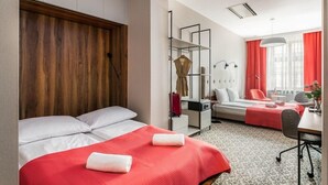 A hotel room with a bed, a desk, a chair, a wardrobe, and a window with curtains. - No.23 Premium Aparthotel (Kraków)