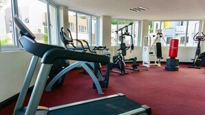 Uma academia com esteiras, bicicletas ergométricas e aparelhos de musculação.