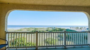 Een balkon met uitzicht op het strand en de zee.