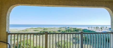 Ein Balkon mit Blick auf den Strand und den Ozean.