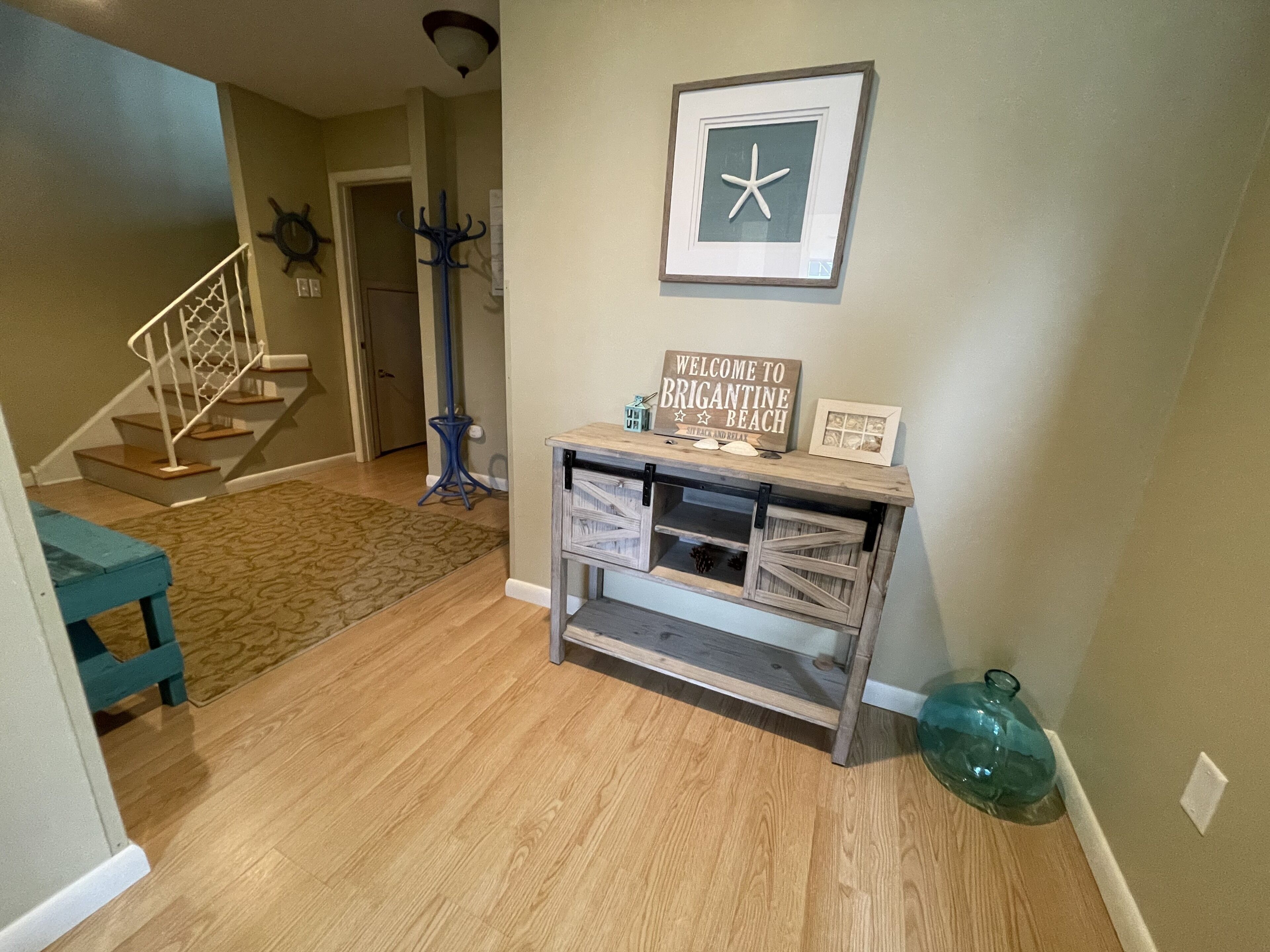 A wooden floor, a staircase, a wall-mounted sign, and a decorative item.