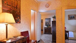 Een hotel lobby met een bureau, stoel en een schilderij aan de muur.