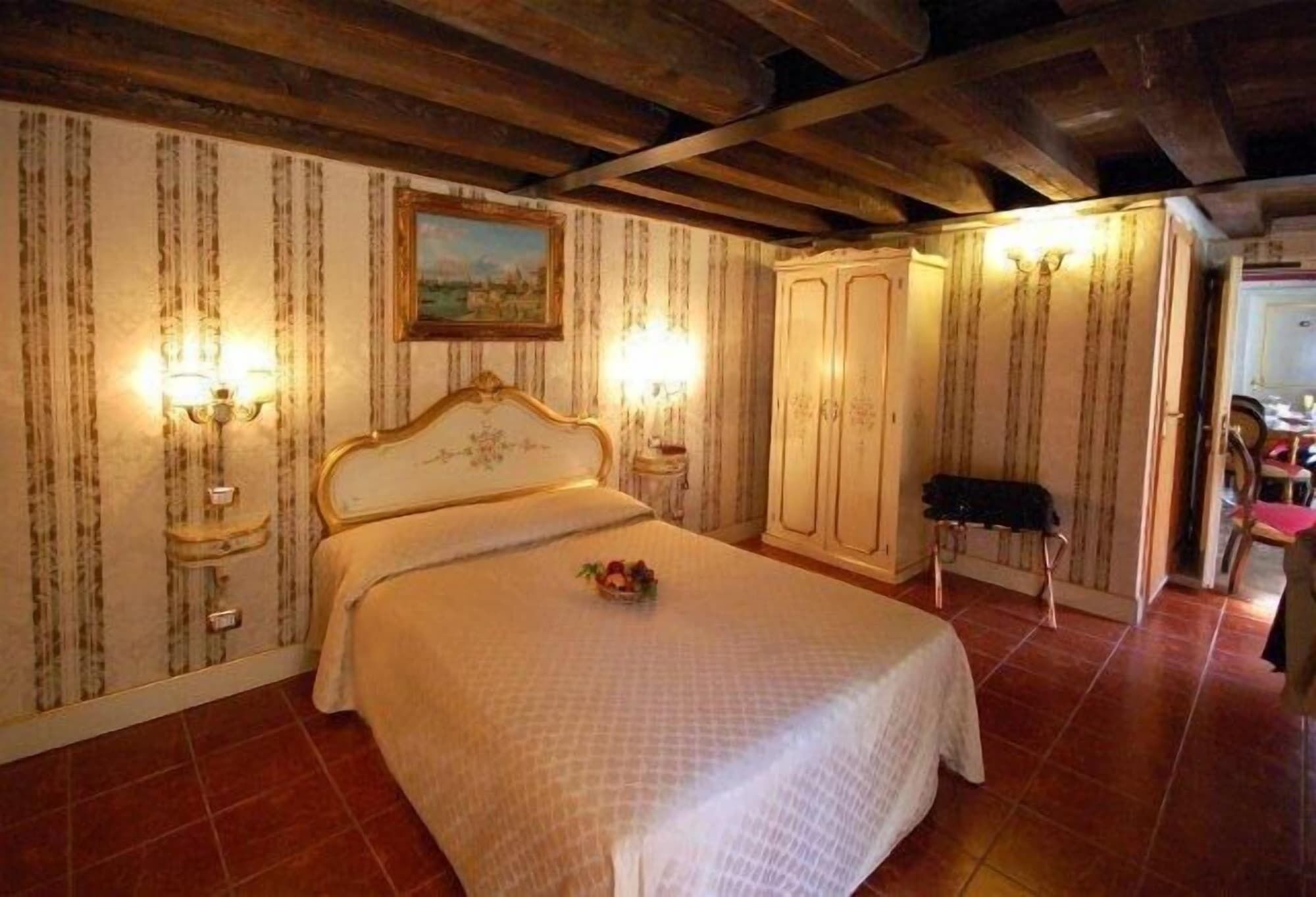 Une chambre à coucher avec un lit, des tables de chevet, une armoire et un tableau au mur.