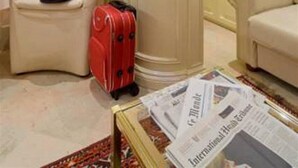 A hotel room with a seating area, a minibar, and a luggage stand. - Hotel Cannaregio 2357 (Venice)