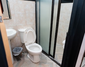 A bathroom with a toilet, sink, and shower area. - Davao Royal Suites and Residences (Davao)