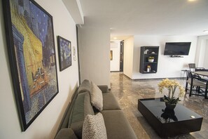 Un soggiorno moderno con un divano, un tavolino da caffè con una pianta e opere d'arte alle pareti.