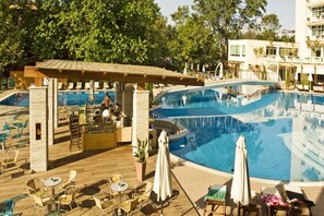 Un área de piscina con sillas de descanso y un bar.