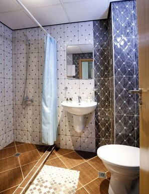 A bathroom with a shower, sink, and toilet. - Grand Hotel Nirvana (Nessebar)