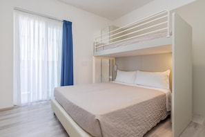 A room with a bunk bed, a large window with curtains, and a bed with a white comforter. - Hotel Madera (Jesolo)