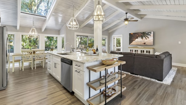 A spacious kitchen with a large island, pendant lights, and a ceiling fan. - Single level Sea Pines home with a hot tub, just a short walk to the beach! (Hilton Head)