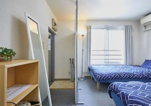 Relax in a serene space with a comfortable bed, bedside table, and large window.