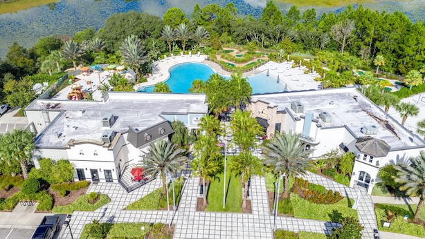 A resort with a swimming pool, landscaped gardens, and a view of a lake. - Amazing New 5 Bedroom 4.5 Bathroom Townhome with Private Pool (Davenport)